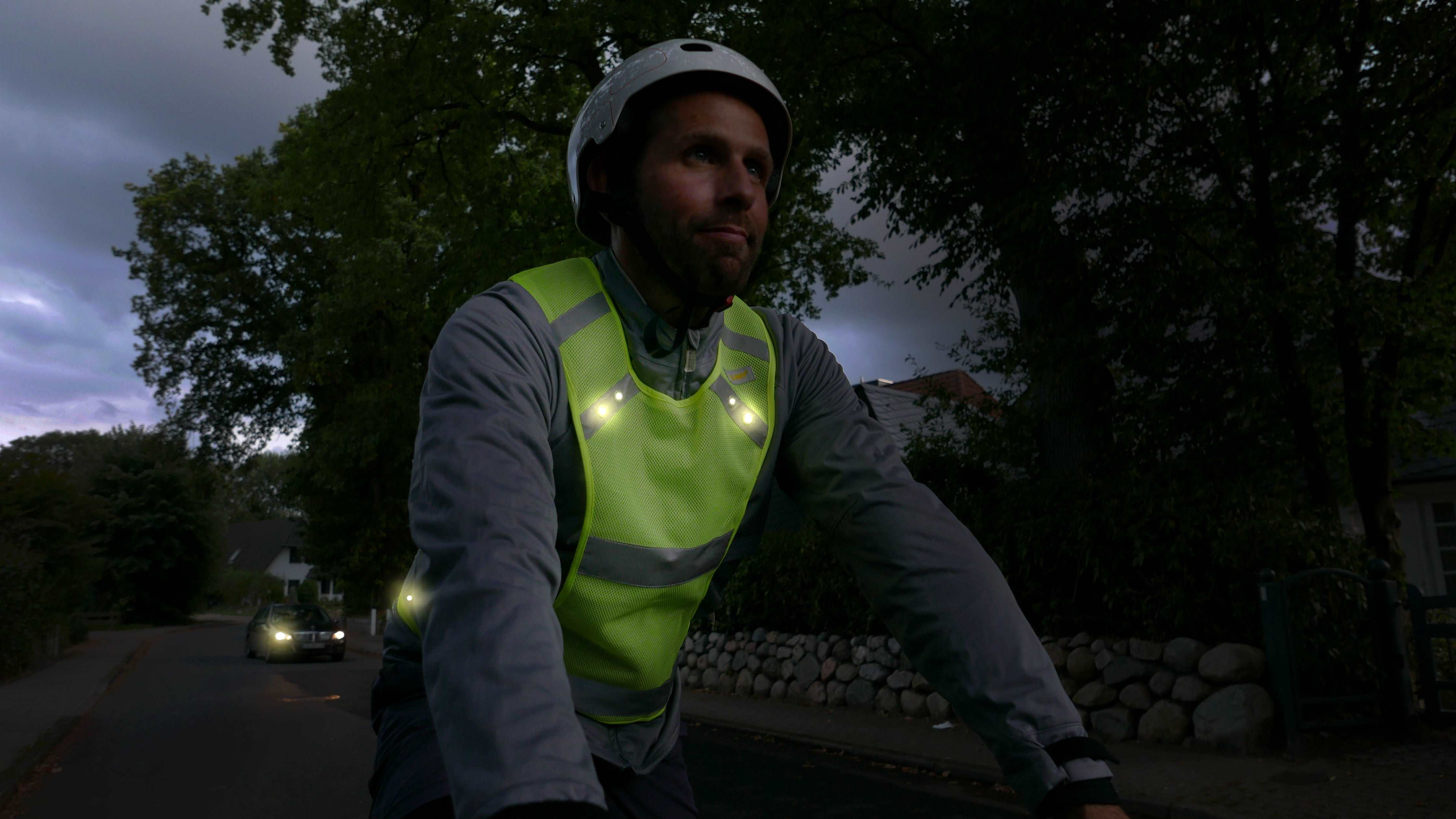 Mensch mit Warnweste auf einem Fahrrad